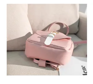 Detail of pink mini leather backpack with buckle on a beige sofa background