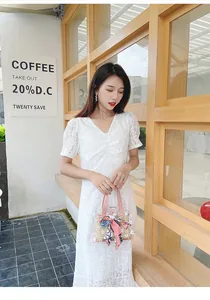 Détail du mini sac seau transparent avec motifs marguerites et foulard en soie rose