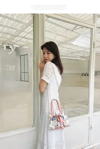 Détail d'un sac seau transparent en PVC avec imprimés marguerites et foulard en soie