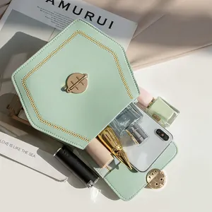 Mint green hexagonal shoulder bag with gold V-stitching and magnetic buckle storage