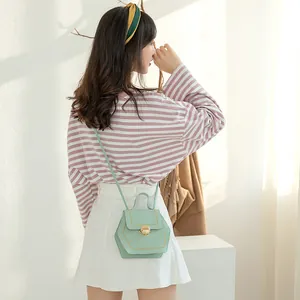 Mint green hexagonal mini crossbody bag with yellow contrast stitching and gold lock