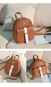 Close-up of brown PU leather mini backpack with gold buckle and bow details