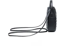 Side view of black quilted leather mini crossbody bag with zipper and top handle