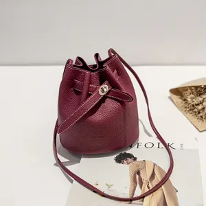 Deep red lychee texture leather bucket bag with contrast stitching and silver lock closure