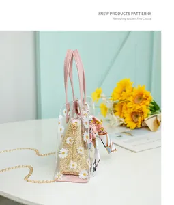 Détail du sac seau en PVC transparent avec marguerites et poignée en cuir rose