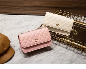Detail van roze en beige gewatteerde crossbodytassen met gouden ringgespen en kettingriemen