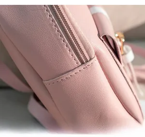 Detailed close-up of precise stitching and high-quality zipper on light pink leather bag