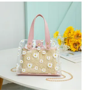 Détail du sac seau en PVC transparent avec imprimés marguerites et pochette en paille
