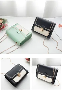 Detail view of the accordion bottom structure and golden chain strap on stylish square bag