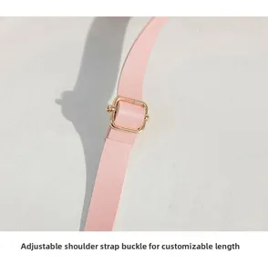 Detail of pink leather strap with a gold adjustable metal buckle for length control