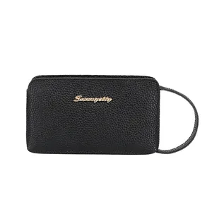 Elegant black pebble leather wristlet clutch bag with gold brand lettering and zipper