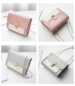 Detail view of contrast color crossbody bag with gold lock and delicate chain strap