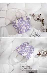 Détail du petit sac seau violet à motif de marguerites avec poignée et sangle