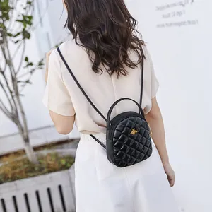 Chic black quilted mini backpack with golden bee hardware and versatile dual-use straps