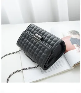 Détail du sac bandoulière en cuir matelassé noir avec chaîne en métal et fermoir tournant