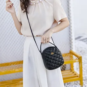 Women black quilted mini backpack with golden bee emblem and adjustable shoulder strap