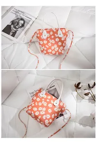 Détail du sac seau orange avec imprimé marguerites et texture en toile renforcée