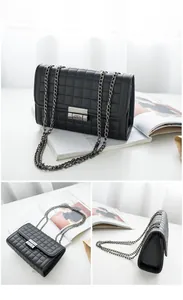 Détails de la texture en cuir noir matelassé et fermoir à chaîne argentée du petit sac