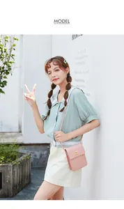 Detail of light pink mini phone bag featuring scalloped edges and golden twist lock closure