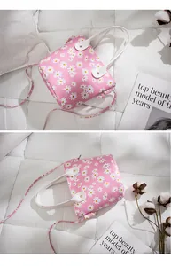 Détail du mini sac seau rose avec motifs de marguerites et bandoulière réglable