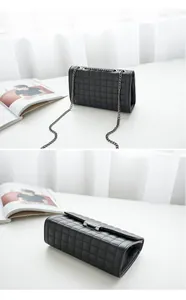 Détail macro du sac à bandoulière en cuir noir matelassé avec chaîne et fermoir