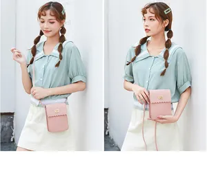 Detail of pink PU leather crossbody phone bag with scalloped edge and gold twist lock