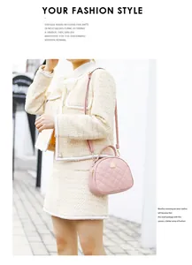 Piccola borsa a mano rosa a semicerchio con ricamo trapuntato indossata da modella
