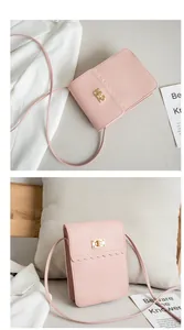 Detail of pink vertical crossbody bag with scallop edge flap and gold metal twist lock