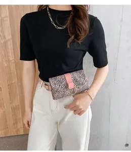 Detail of pink and black zebra print belt bag with a gold metal ring buckle