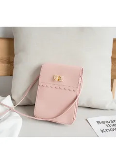 Detail of pink leather phone bag featuring a golden square lock and wavy lace trim