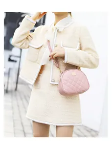 Dettaglio della borsa trapuntata rosa abbinata a un elegante outfit beige all'aperto