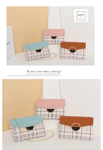Detail of crossbody chain bag with plaid pattern and circular metal magnetic buckle