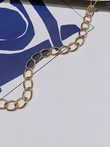 Nahaufnahme der goldenen Metallkette mit polierten flachen Gliedern für modische Taschen