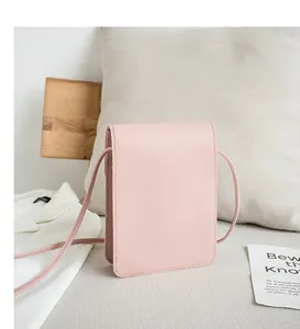 Detail of light pink crossbody phone bag with leather texture and flap closure