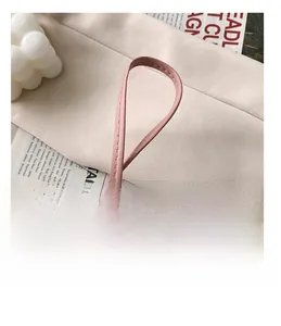 Close-up of pink synthetic leather shoulder strap with fine stitching and gold ring detail