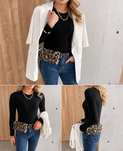 Detailaufnahme der Leoparden-Gürteltasche mit Goldkette auf weißem Blazer