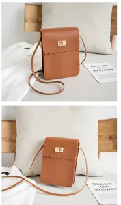 Close-up of brown PU leather bag with scalloped edge and gold rectangular metal lock