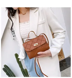 Close-up of brown quilted mini crossbody bag with gold metal twist lock detail