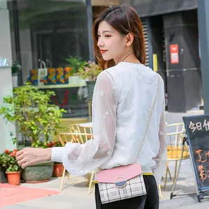 Pink and beige checkered crossbody flap bag with gold chain strap and metal buckle