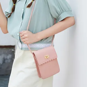 Pink crossbody phone bag with scalloped edges and a golden square metal twist lock