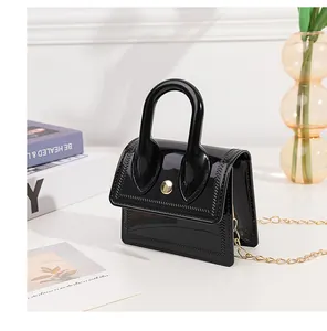 Close-up of black jelly mini bag with chevron stitching and gold chain strap details