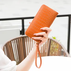 Portafoglio lungo arancione da donna con stampa coccodrillo, cinturino e zip