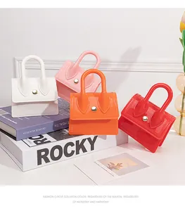 Close-up of four colorful mini PVC jelly handbags with gold buckles and top handles