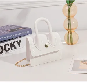 Close-up of white mini PVC jelly bag featuring herringbone stitching and gold chain strap
