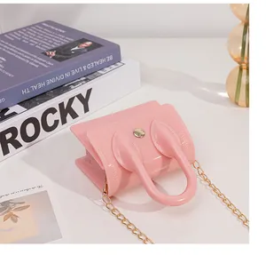 Macro detail of pink jelly mini bag with gold buckle and embossed side arrow pattern