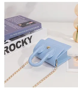 Detail of light blue mini jelly bag with gold chain strap and accordion side folds