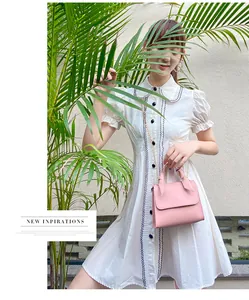 Mini sac carré en cuir rose avec nœud et chaîne dorée présenté dans un cadre chic