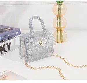 Close-up of mini silver glitter jelly bag with gold chain strap and metal buckle