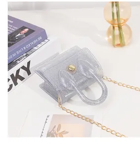 Close-up of glittery silver PVC jelly bag featuring a gold chain and circular clasp