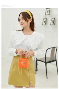 Detail of orange jelly mini bag with pearl handle and golden heart lock on model